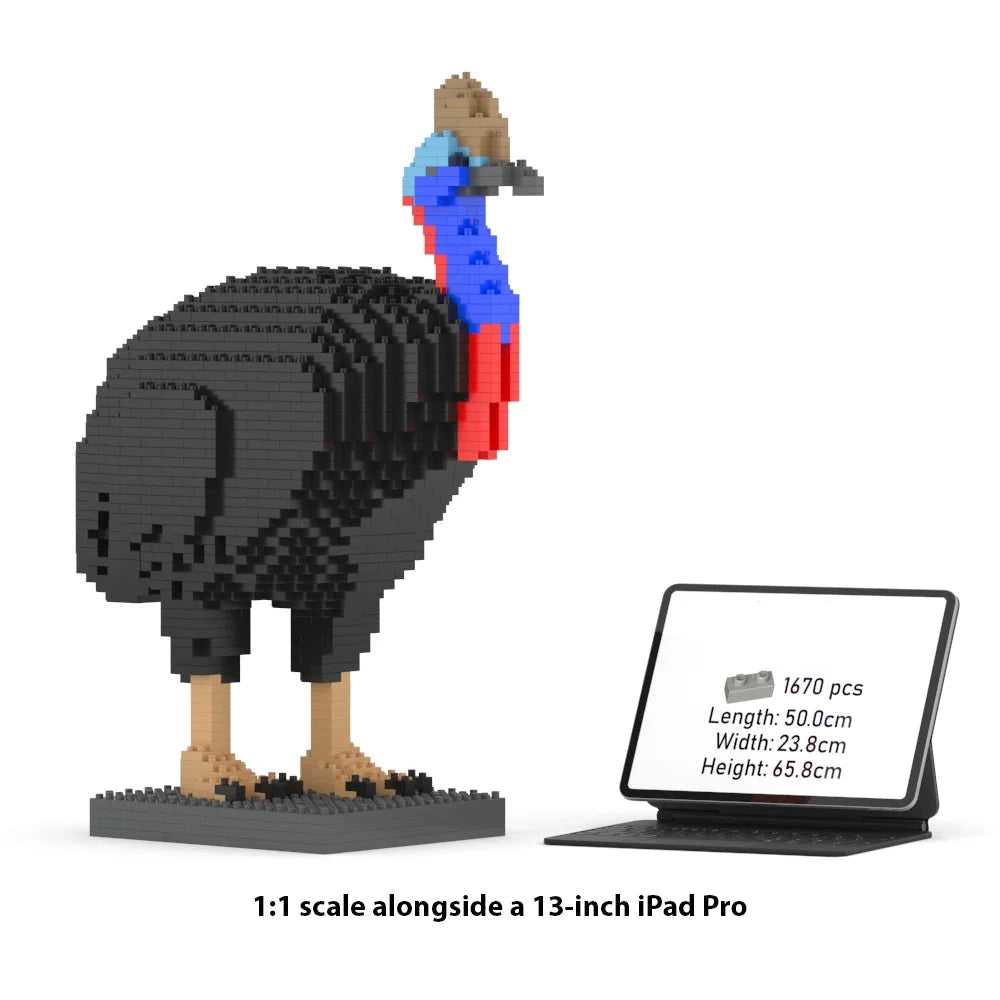 A 1:1 scale brick-built model of a cassowary made from black, blue, red, tan, and brown blocks, shown next to a tablet displaying product info. Text at the bottom reads '1:1 scale alongside a 13-inch iPad Pro'.