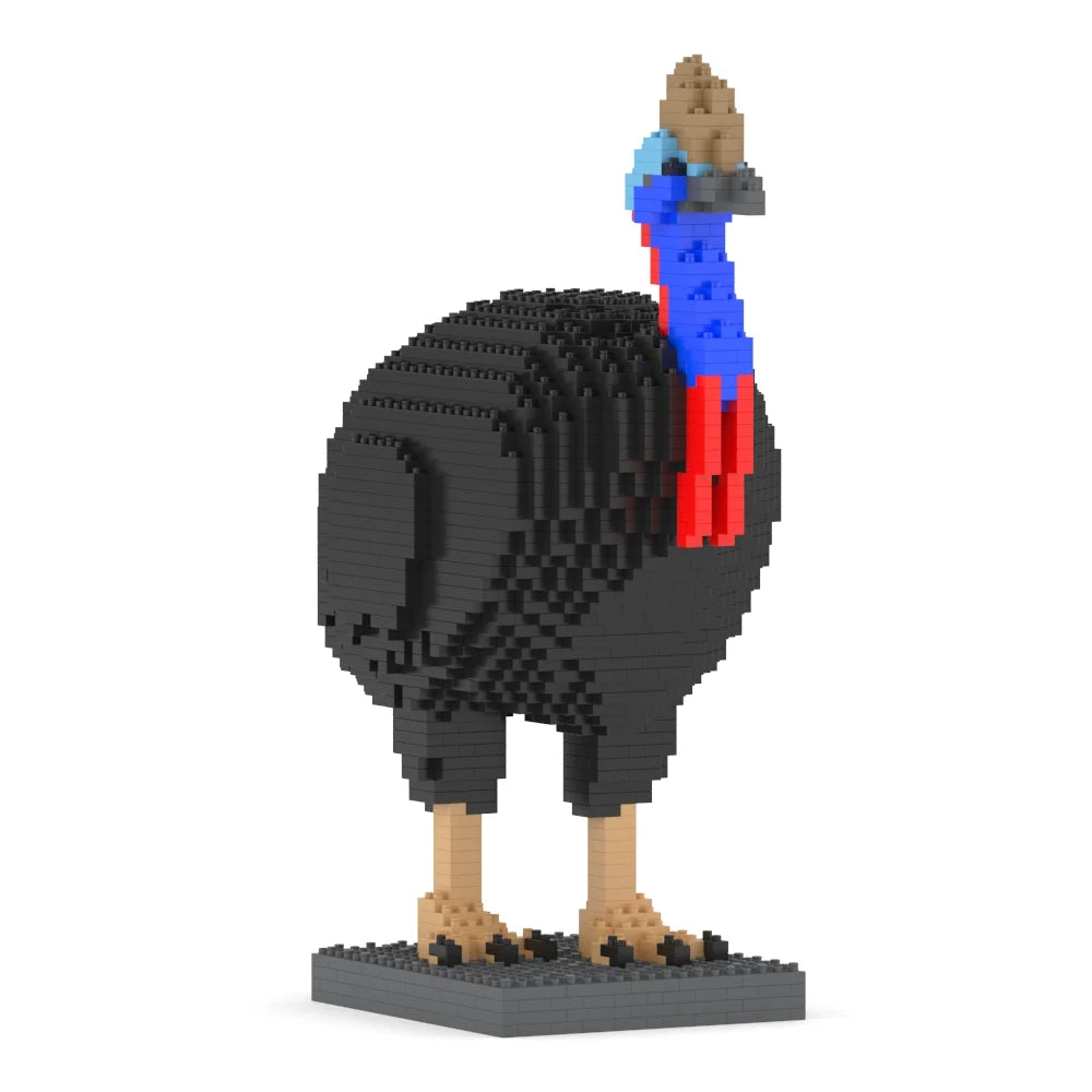 A small toy building-block model of a cassowary bird standing on a dark base, shown against a plain white background. The body is primarily black, with a bright blue neck, red wattle, tan legs and feet, and a brown head.