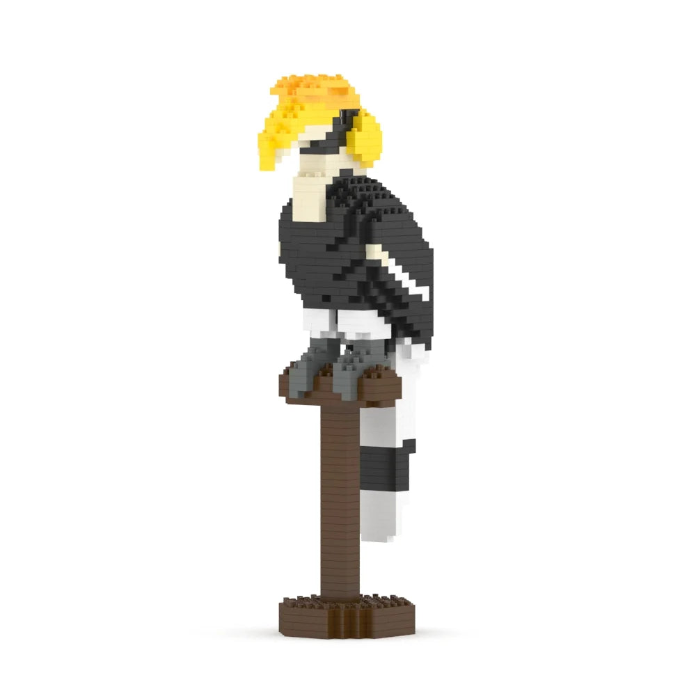 A block-style great hornbill bird sculpture perched on a brown stand, with a yellow crest, black-and-white body, and gray legs, shown on a plain white background.