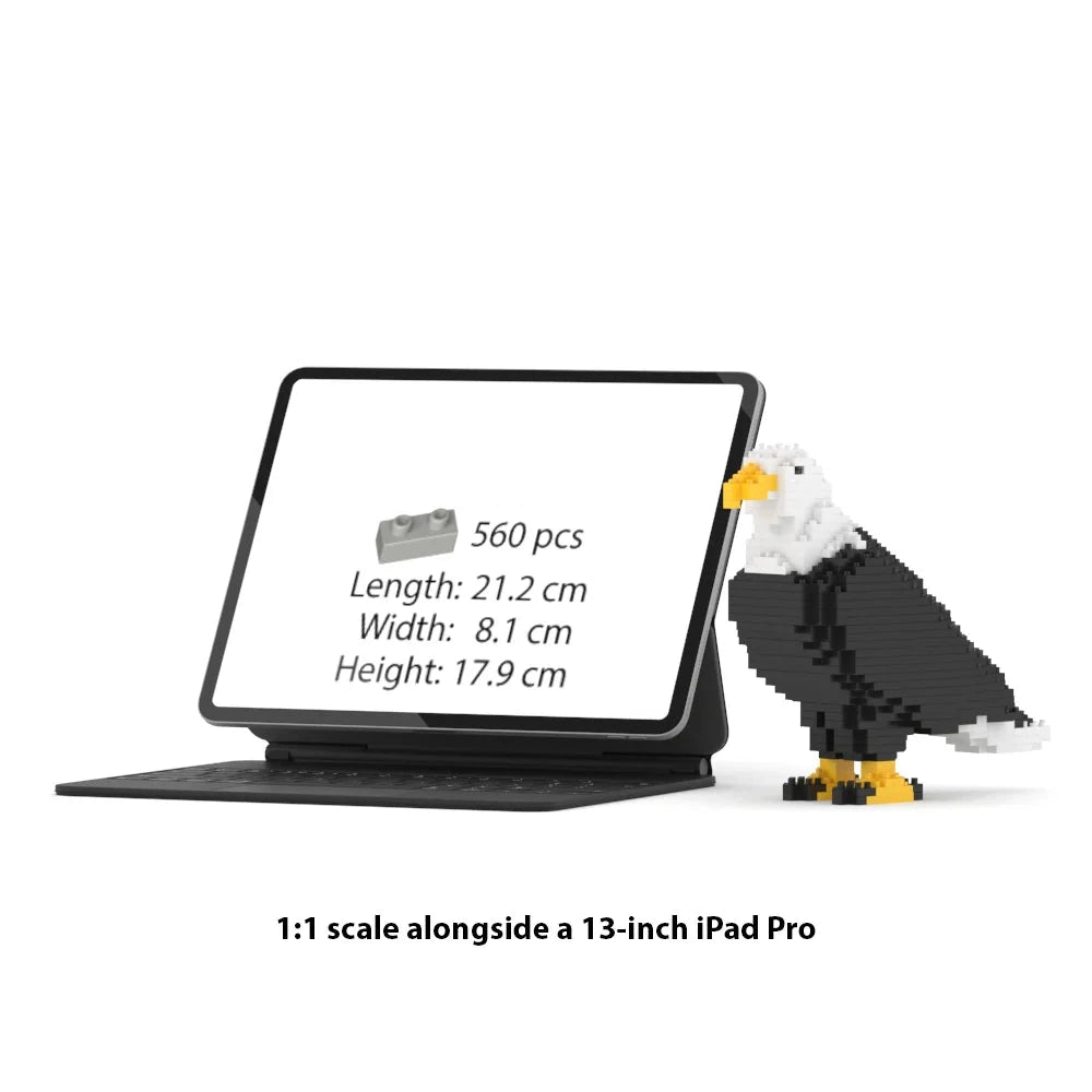 A 1:1 scale brick building set of an iPad Pro in a black tablet case with a built-in keyboard, shown next to a pixelated brick-built eagle on a white background. Text below reads '1:1 scale alongside a 13-inch iPad Pro'.