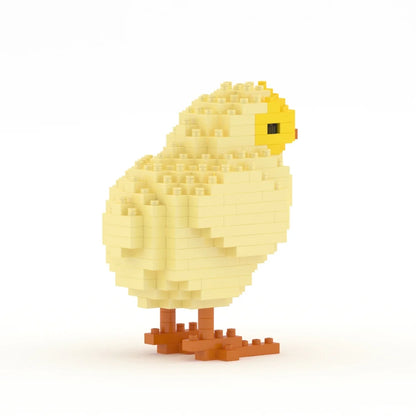 A small chick-shaped toy or model built from light yellow and cream blocks, with a yellow beak and orange-brown feet, shown on a clean white background.