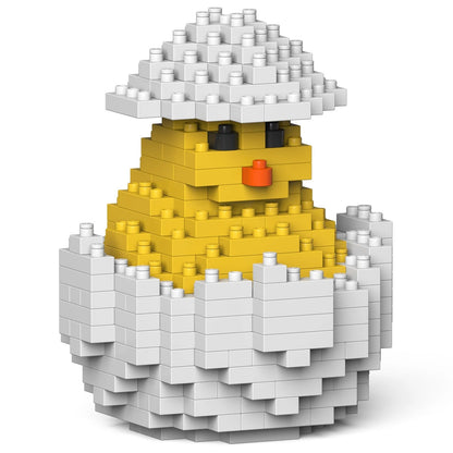 Toy figure of a chick in an egg made of interlocking bricks on a white background