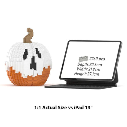 A LEGO-style pumpkin building set shown beside an iPad 13" with a black keyboard case. The pumpkin is made of white, orange, and brown block pieces with a carved face.