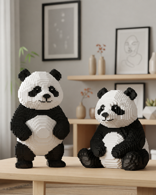 Two panda block sculptures made of interlocking toy bricks, displayed on a light wood table in a modern, softly lit room with framed wall art and shelves in the background.