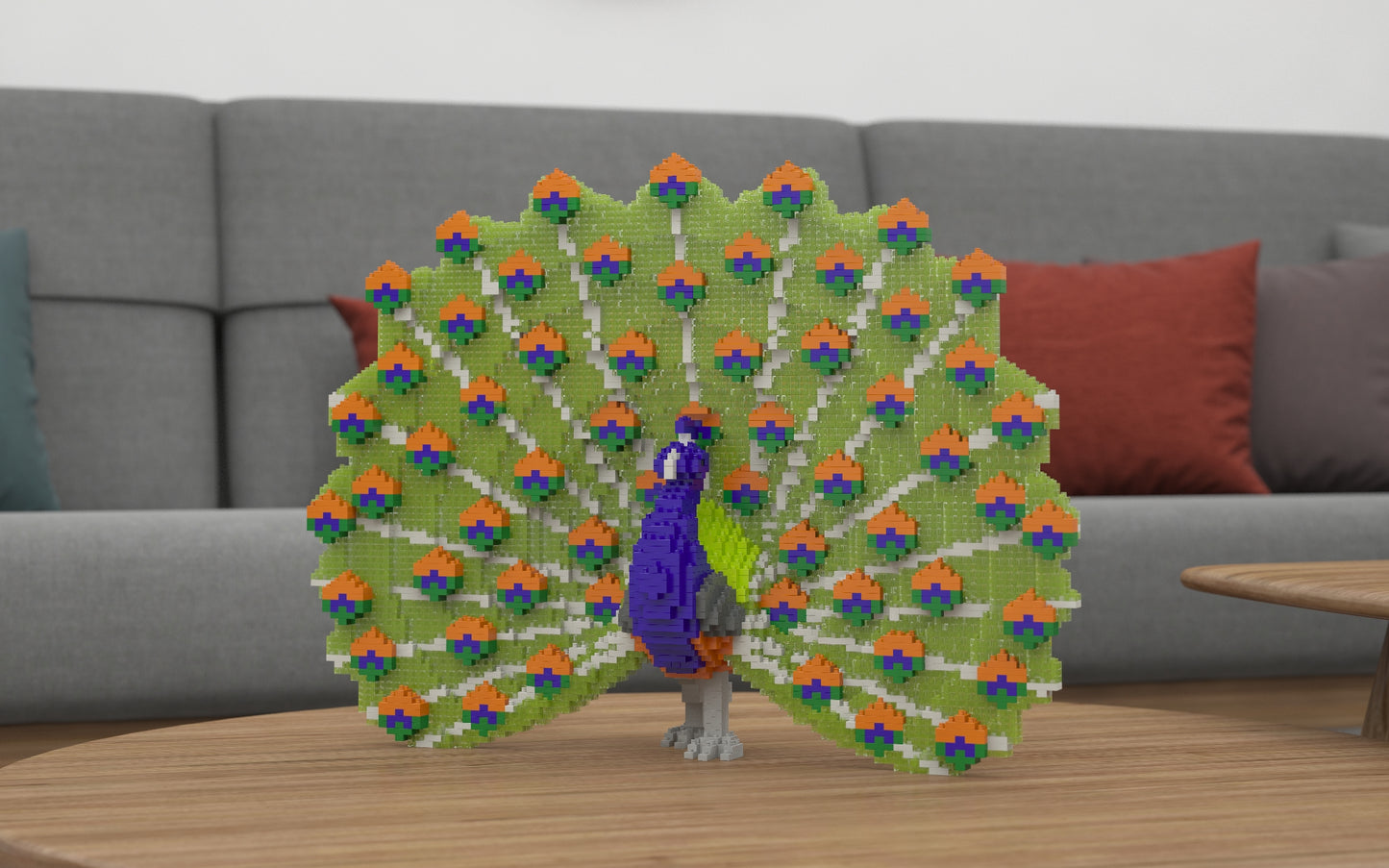A colorful peacock building set with a large fanned tail stands on a round wooden table in front of a gray sofa with red and blue pillows.