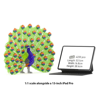 A 1:1 scale peacock building block set shown beside a 13-inch iPad Pro on a white background, with text reading '1:1 scale alongside a 13-inch iPad Pro.' The peacock is constructed from many colorful small blocks, with a green body and tail, purple neck, and orange/blue accents.
