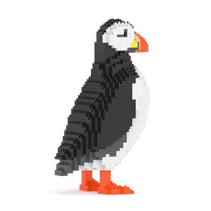 A pixelated puffin bird figure built from small interlocking blocks, shown in side profile on a plain white background. The bird is primarily black and white with bright orange feet and beak accents and a small yellow accent near the beak.