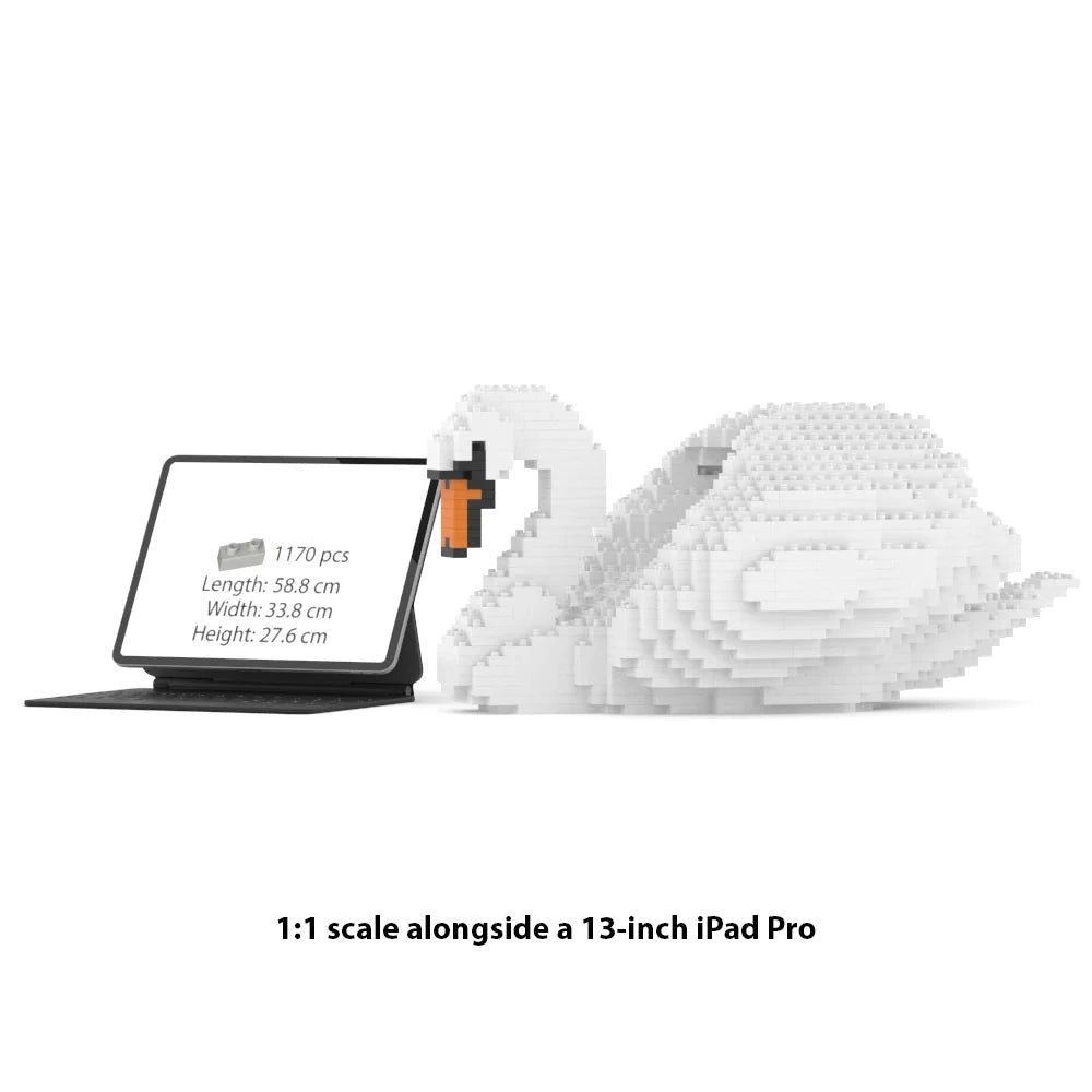 White swan-shaped building block set displayed beside a 13-inch iPad Pro on a white background, with text reading '1:1 scale alongside a 13-inch iPad Pro' below.
