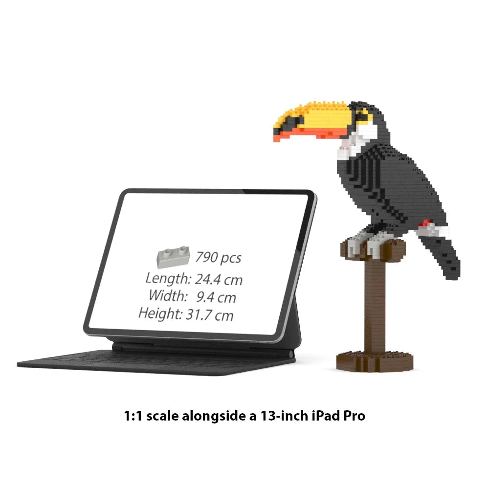 1:1 scale toy brick set of a toucan on a stand, shown next to a 13-inch iPad Pro displaying the product specifications. The text at the bottom reads '1:1 scale alongside a 13-inch iPad Pro'.