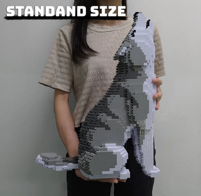 Person holding a standard size gray and white wolf model made of interlocking bricks against a plain background.